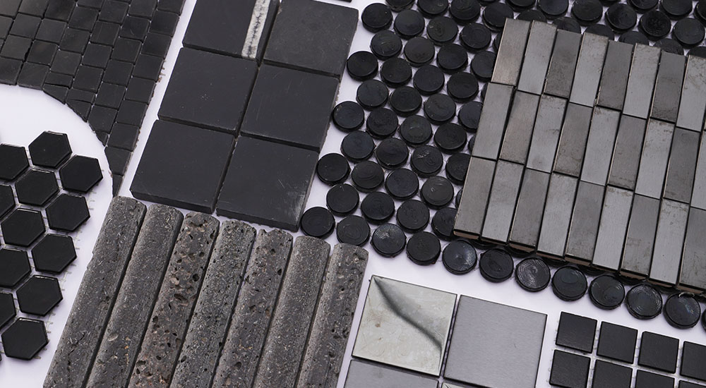 {"default":"Black tile sample collection featuring mixed mosaic shapes and finishes on white background"}
