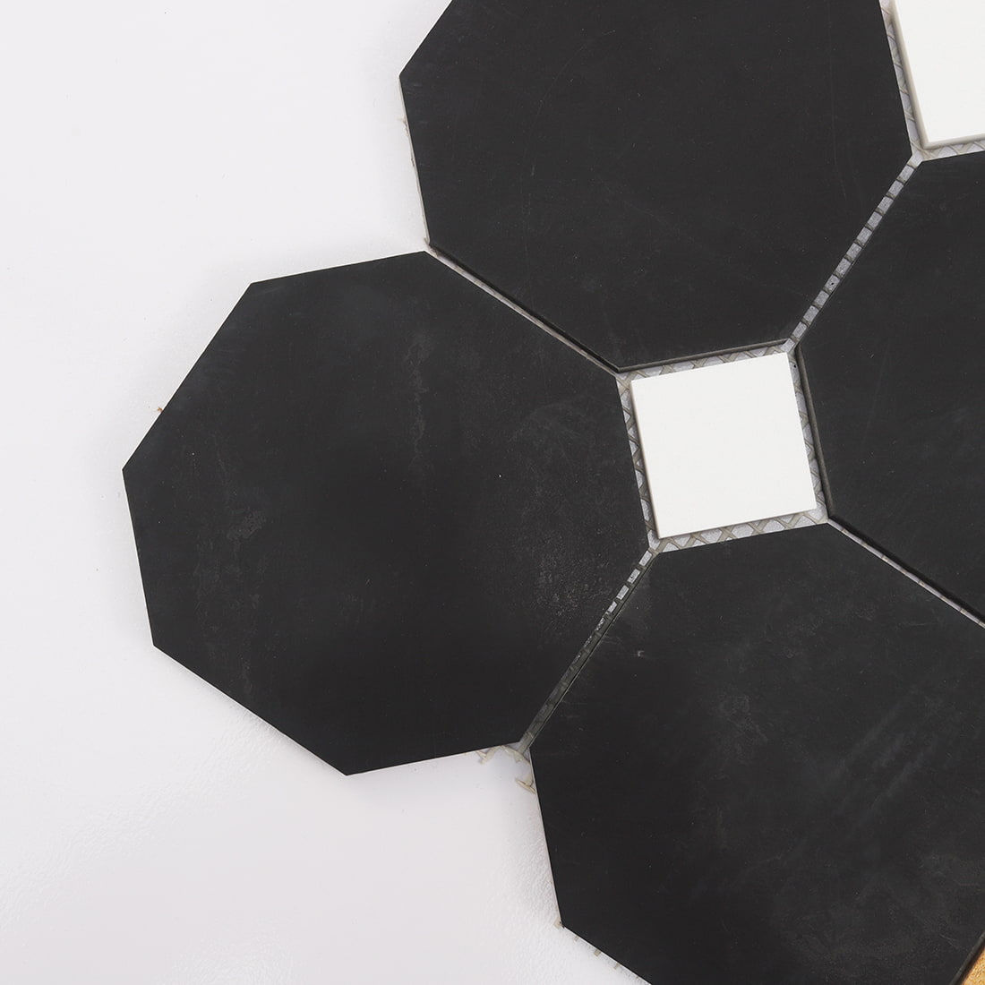 Close up of black octagon marble mosaic tile with a white square insert