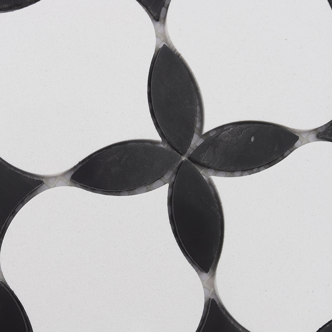 Black petal flower motif between white arabesque marble mosaic tile pieces