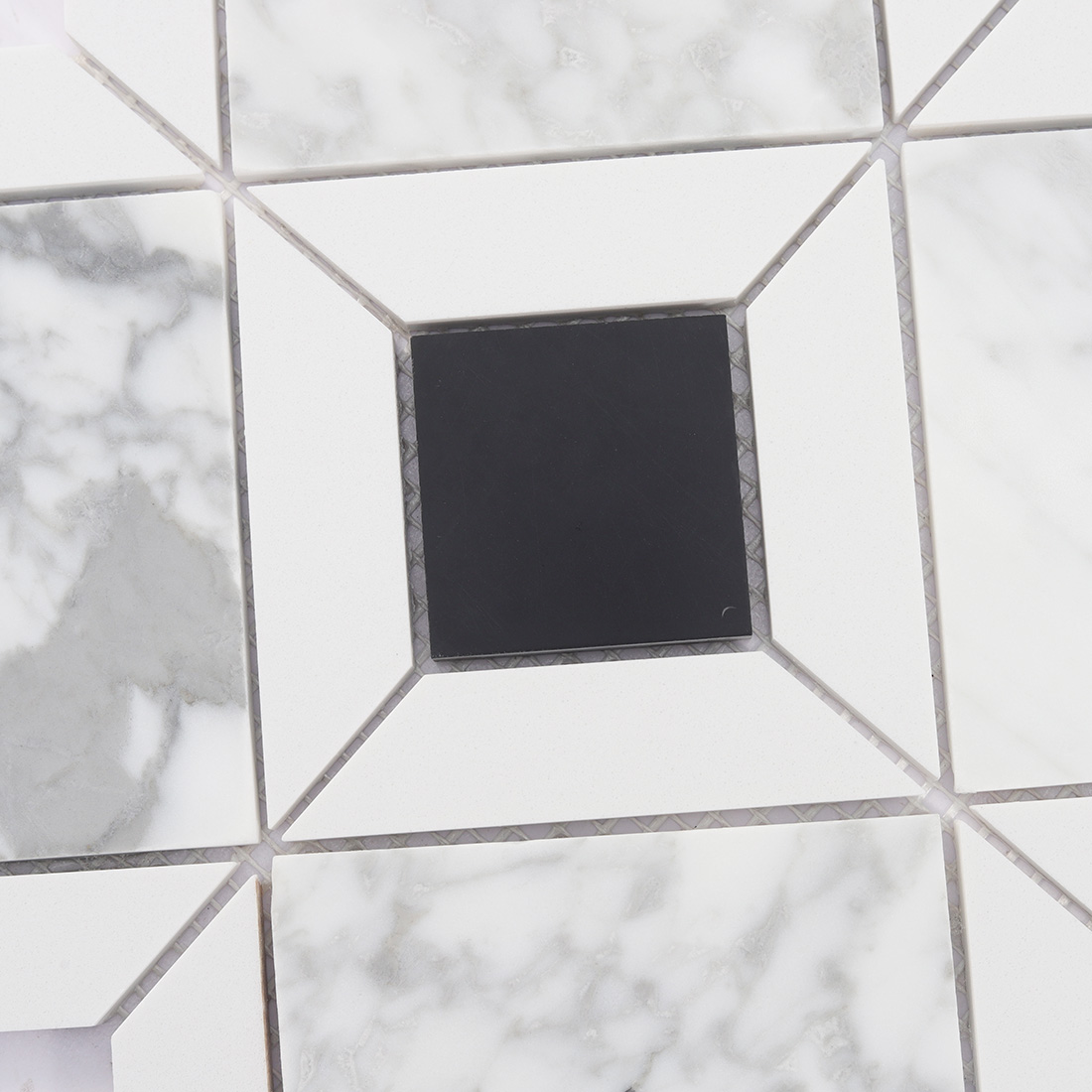 Detail of black square insert in white marble diamond tile pattern