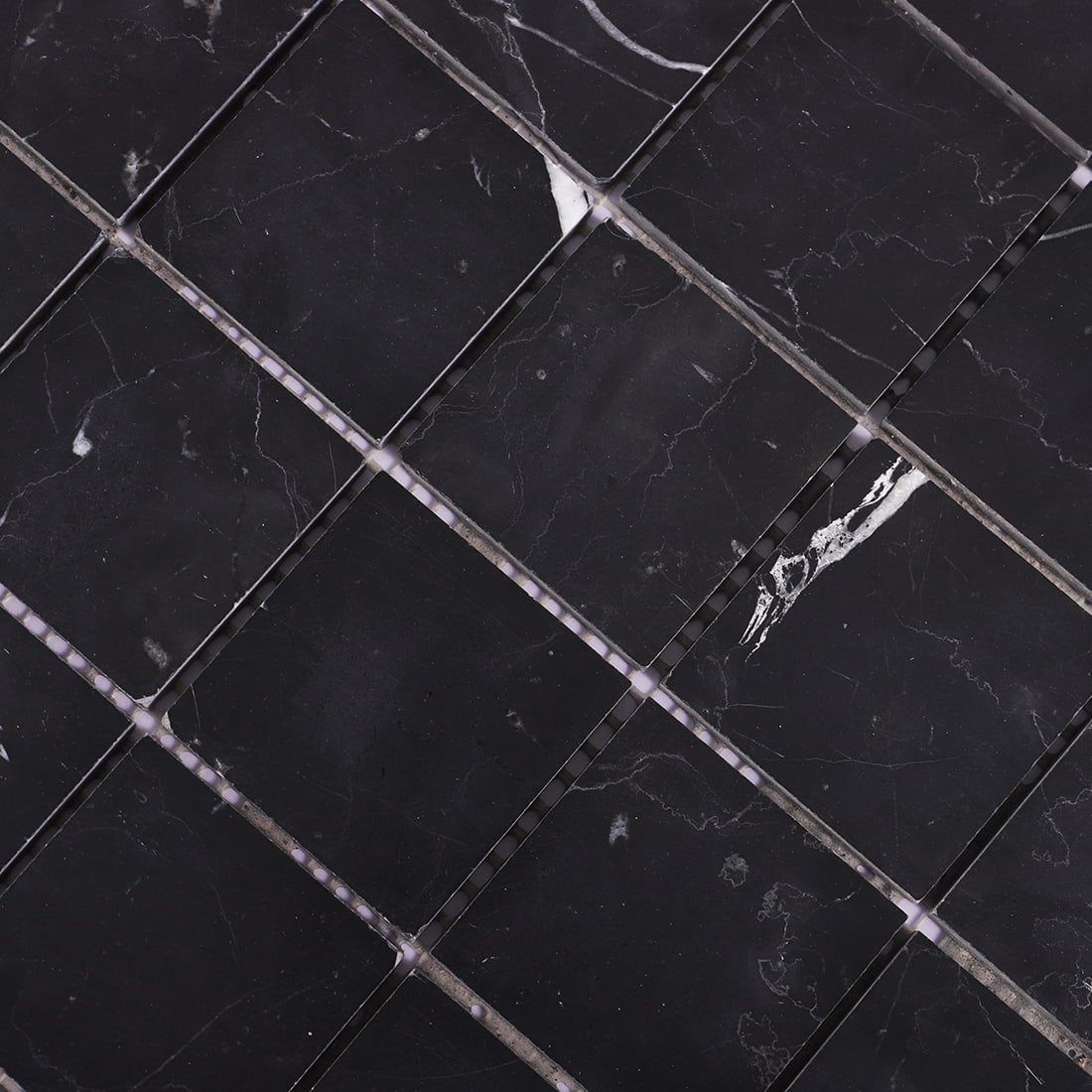 Close-up of black square marble mosaic tiles with delicate white veining