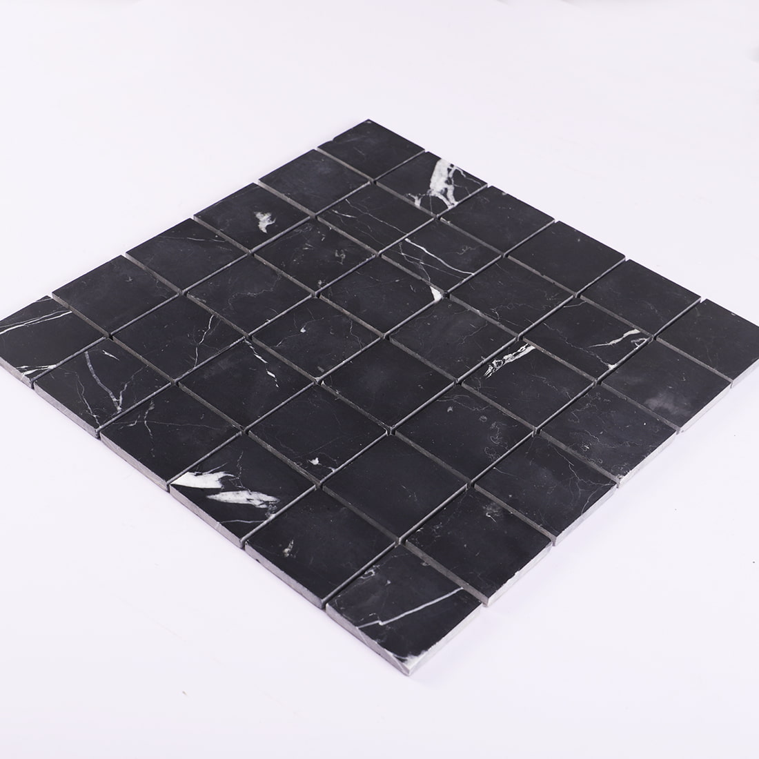 Perspective view of a black square marble mosaic tile sheet in natural stone