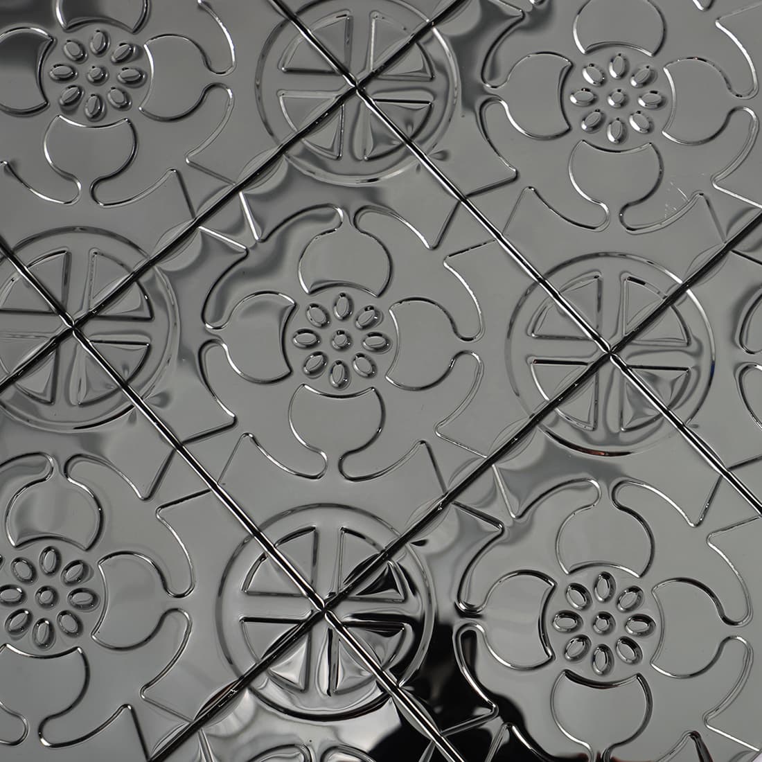 Close up of black stainless steel floral embossed square tile pattern