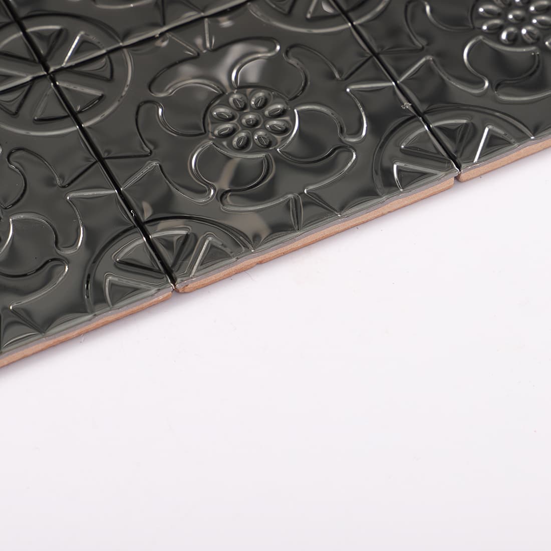 Side view of black stainless steel floral embossed square tiles