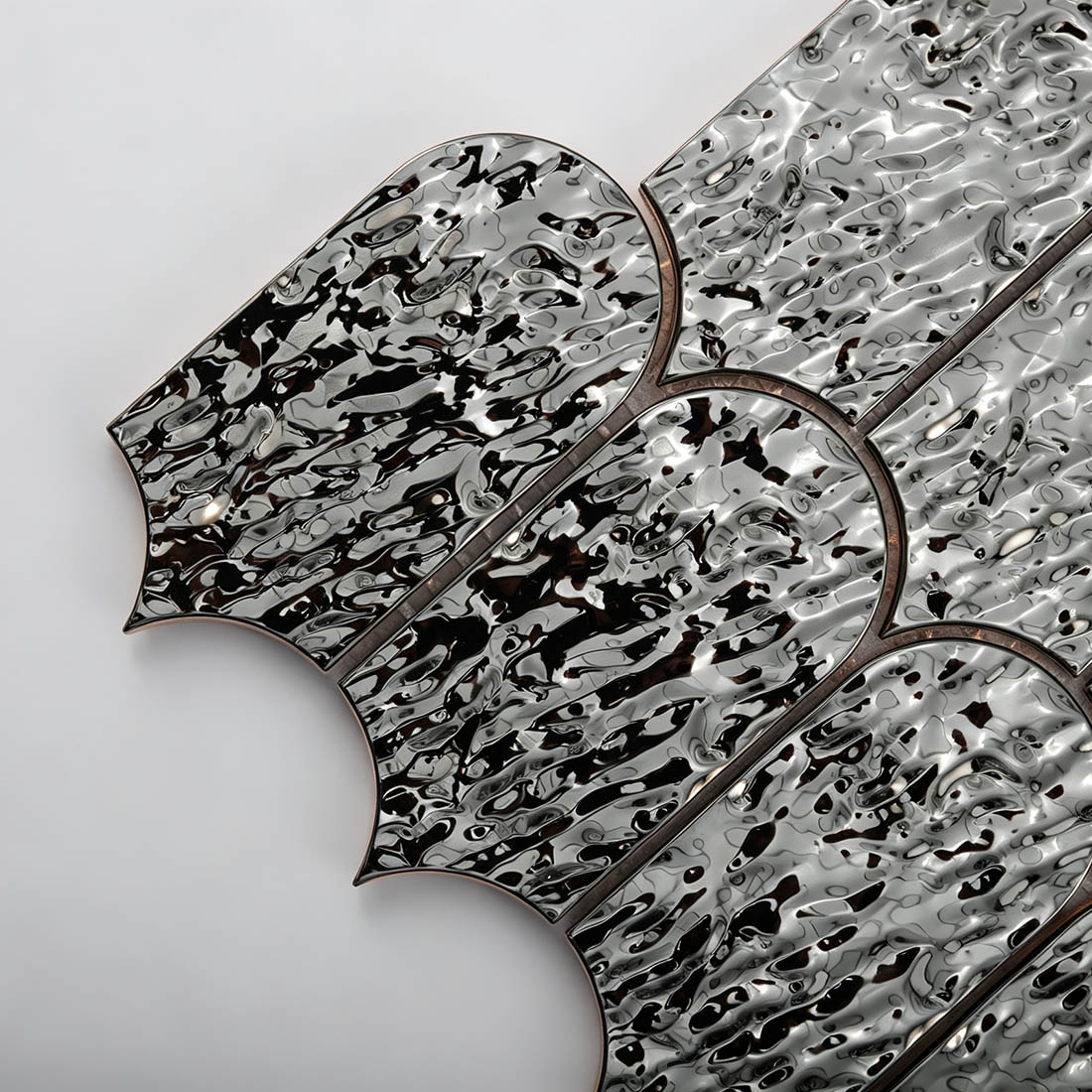 Close-up detail of black water ripple arched metal mosaic tile