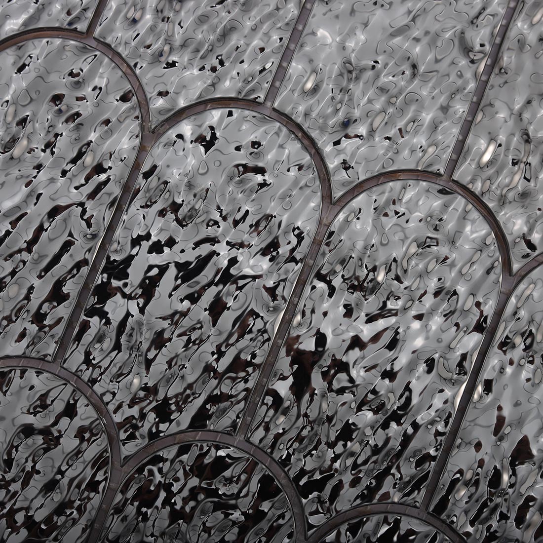 High angle view of black water ripple scalloped mosaic tile surface