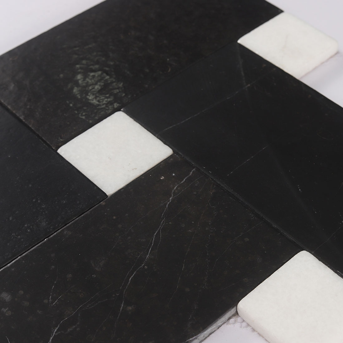 High angle surface texture shot of black and white marble mosaic