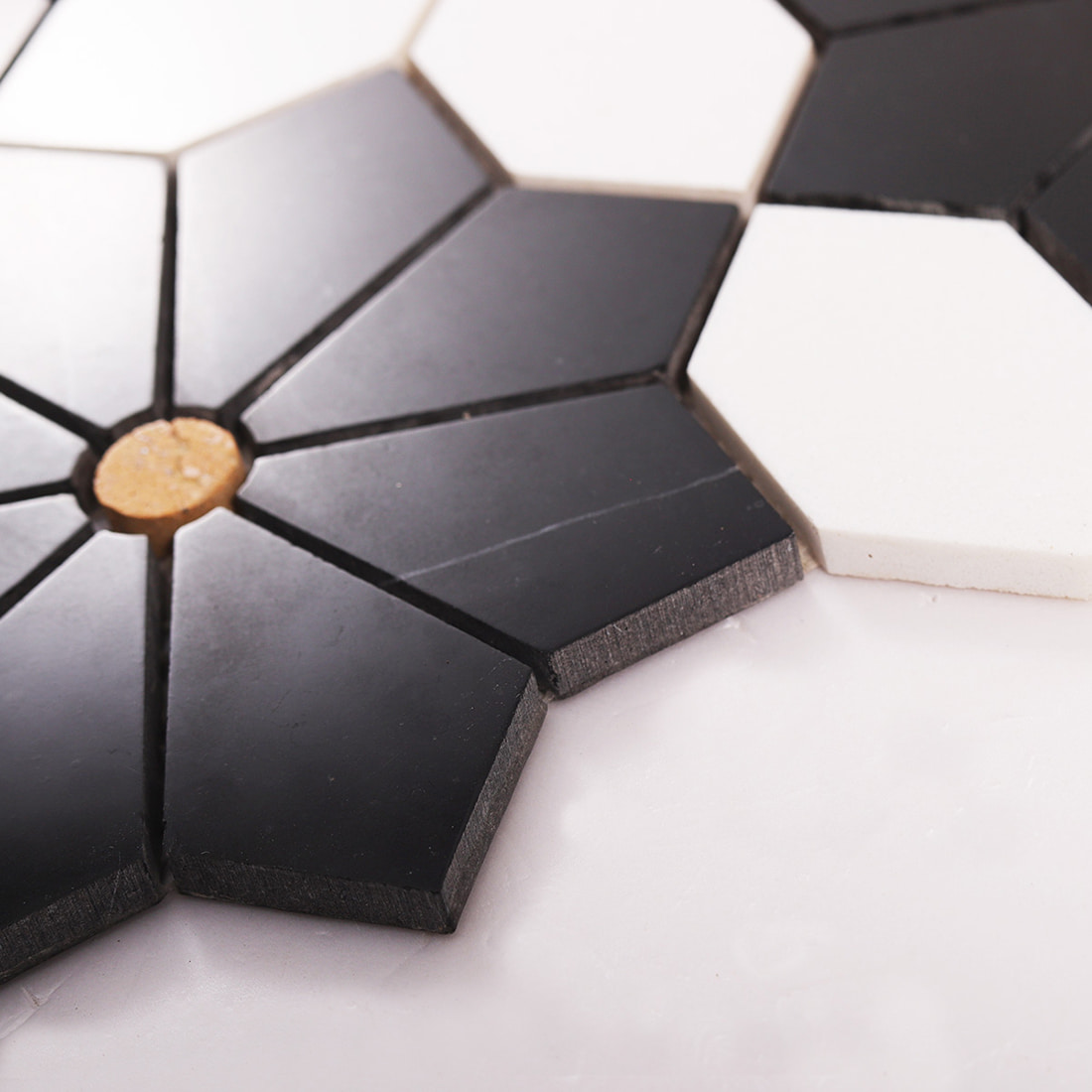 Side view showing thickness and edge profile of black and white flower mosaic tiles