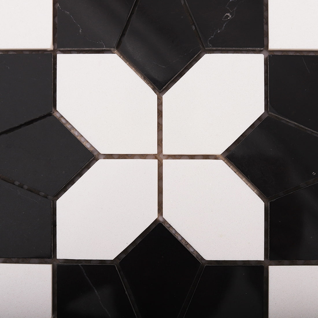 Close up of a single black marble flower mosaic with contrasting white tiles