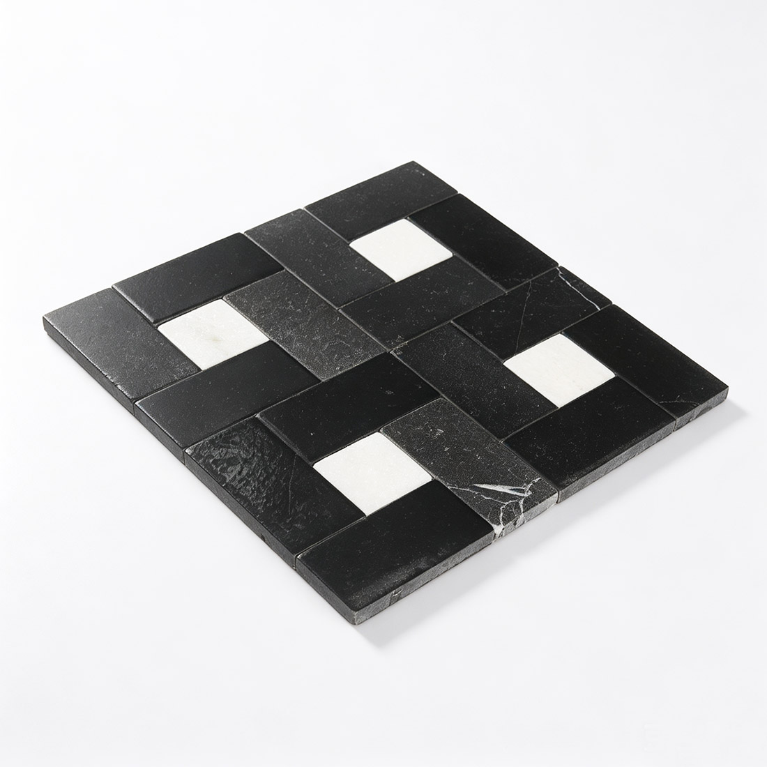 Perspective view of laid black and white pinwheel marble mosaic sheet