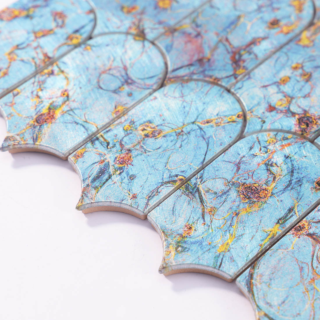 Angle shot of blue gold marbled arched aluminum mosaic tile showing edge