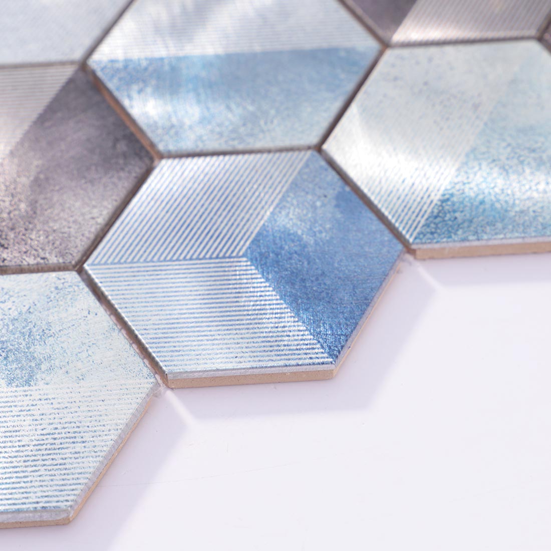 Angle shot of blue grey flat hexagon metal mosaic tile showing smooth edge