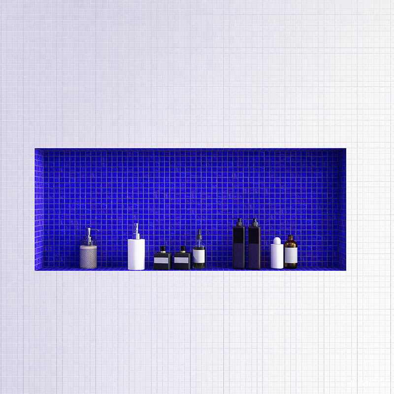 Blue mosaic tile shower niche inset on a white tiled bathroom wall