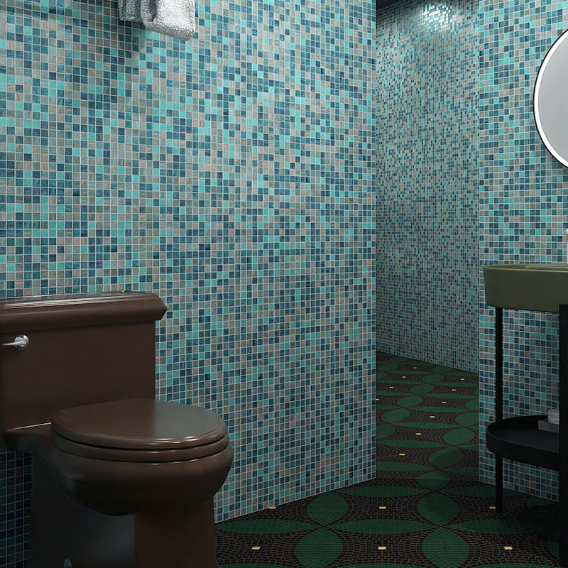 Blue mosaic tiles on small bathroom walls with a walk-in shower and dark fixtures