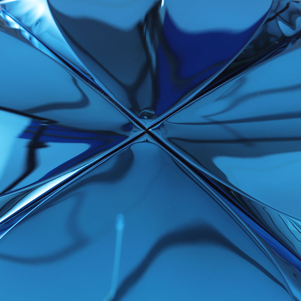 Closeup of blue raised metal tile center with sharp folded pyramid lines