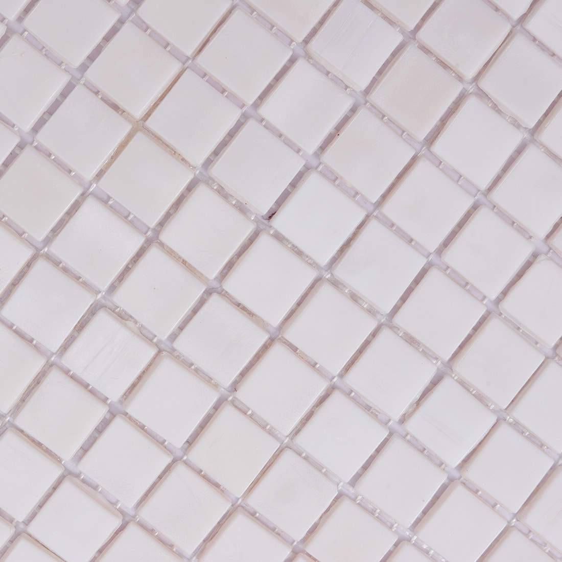 Surface detail of blush pink square glass mosaic tile