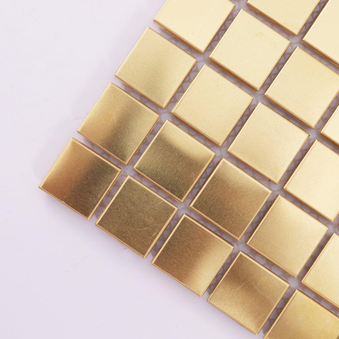 Corner close up of brass square metal mosaic tile
