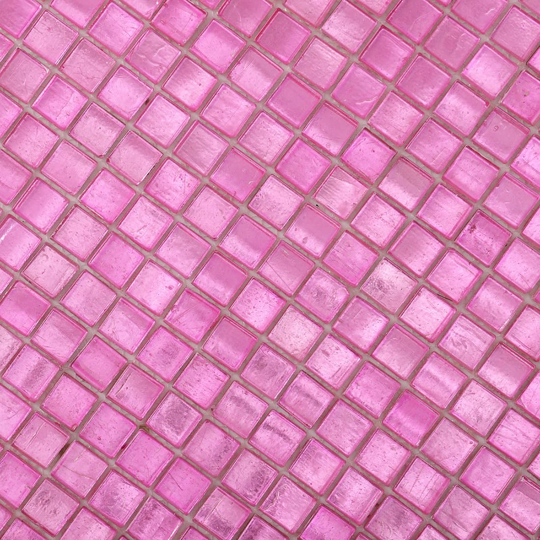 Surface detail of bright pink foil-backed square glass mosaic tile