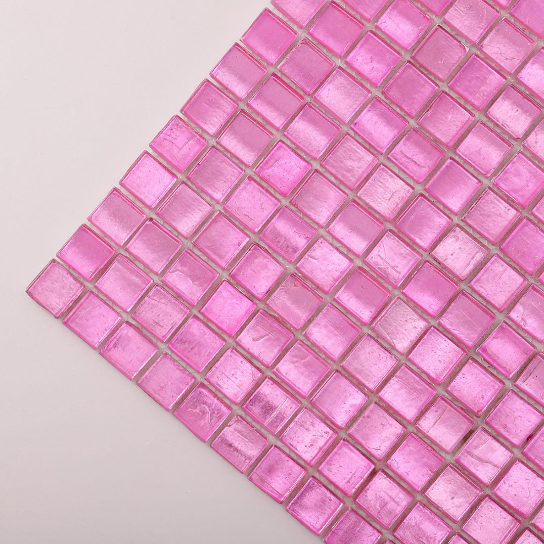 Corner close-up of bright pink foil-backed square glass mosaic