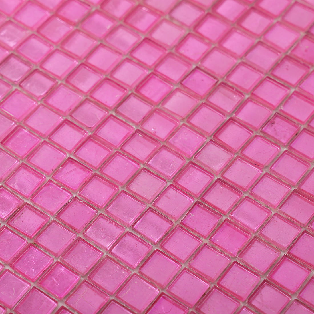 Angled detail of bright pink foil-backed square glass mosaic sheet