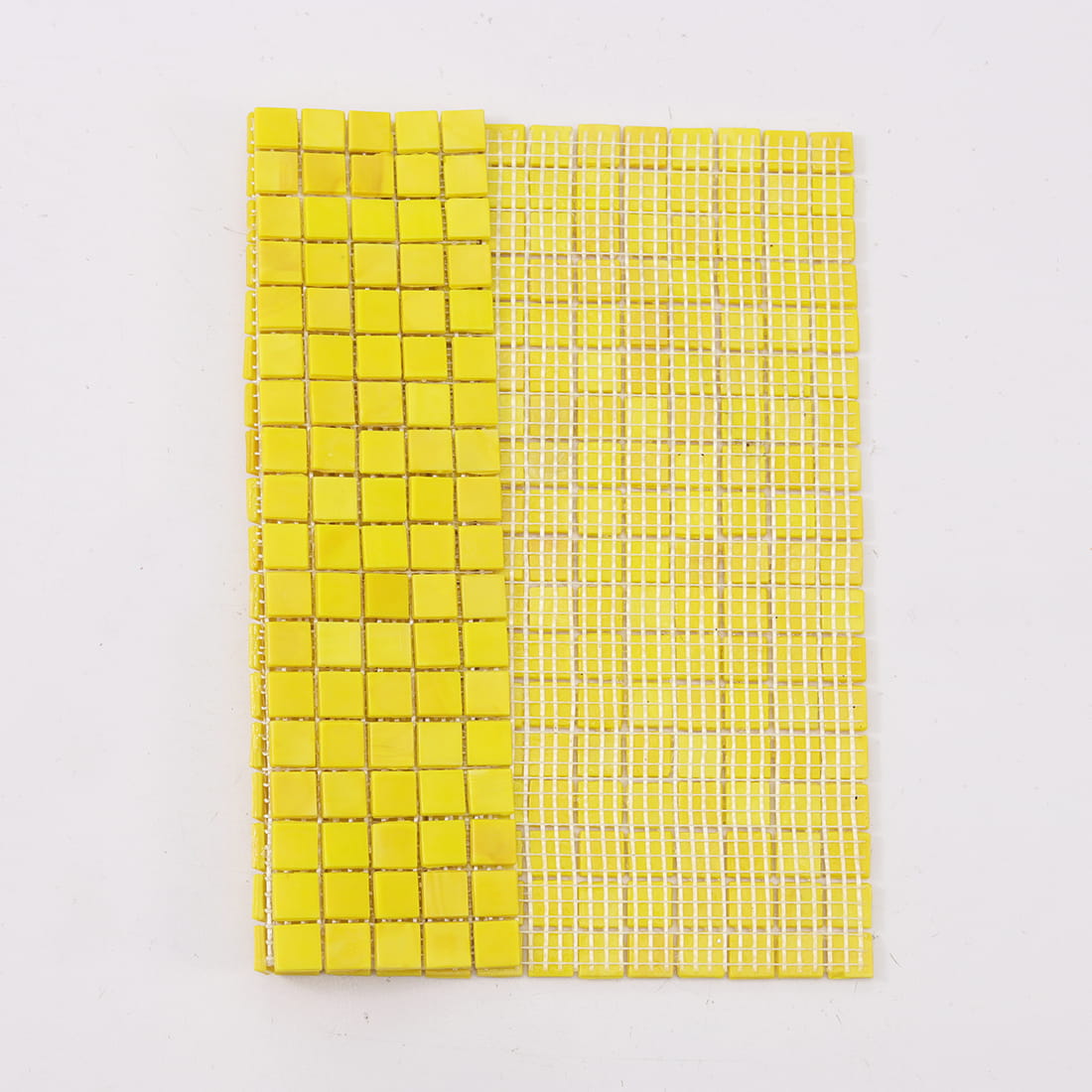 Bright yellow mosaic tile sheet partially folded to show white mesh backing.
