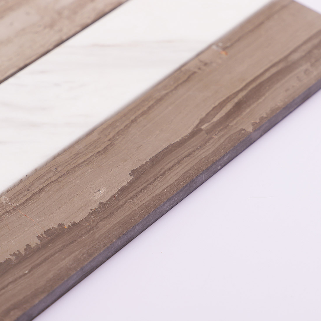 Side view of brown marble strip mosaic tile showing thickness detail.