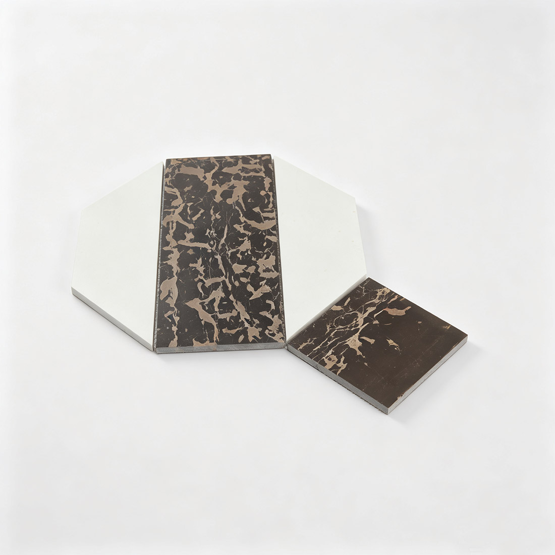Brown and white geometric marble mosaic tile pieces on a white background