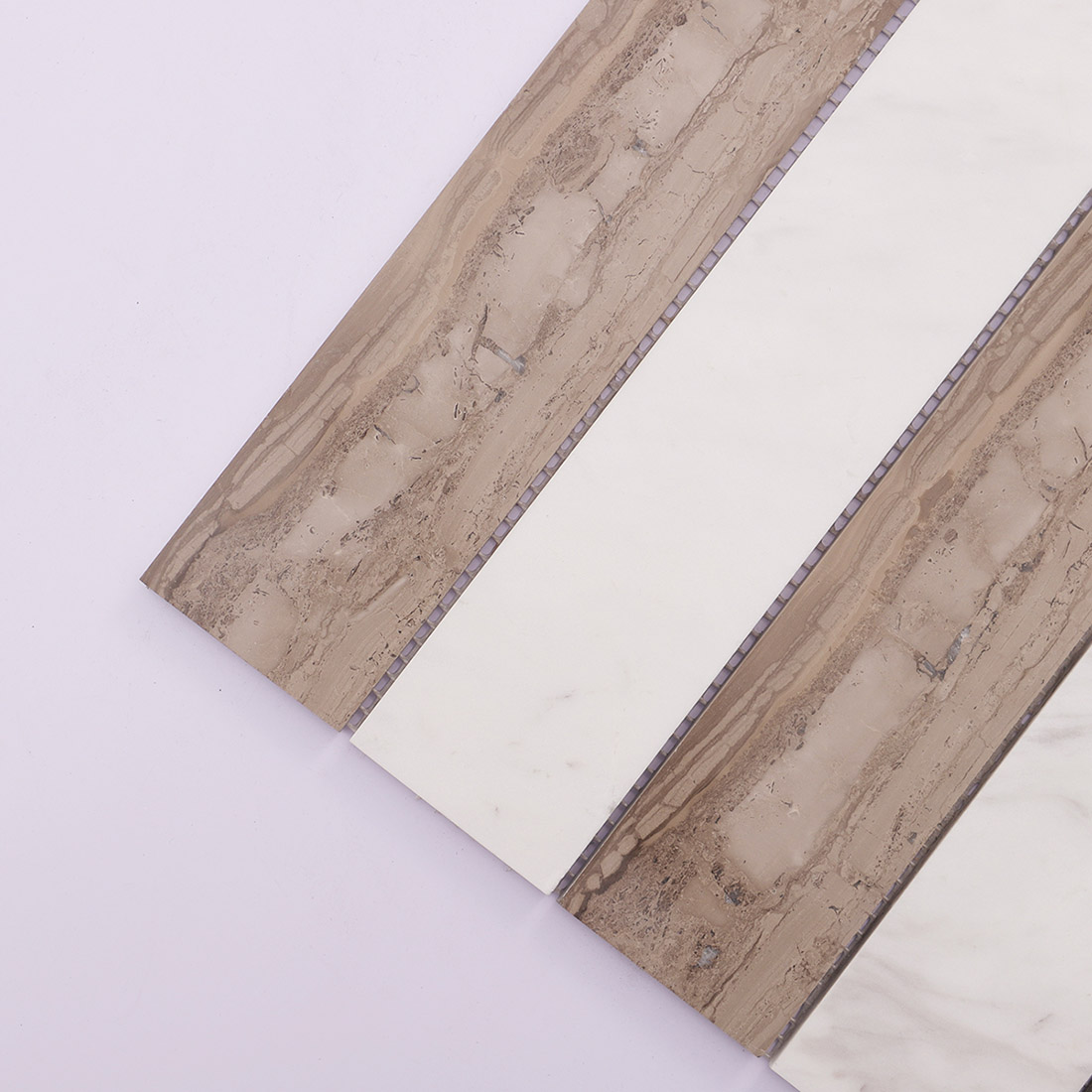 Angled view of brown and white linear marble mosaic with natural stone veining.