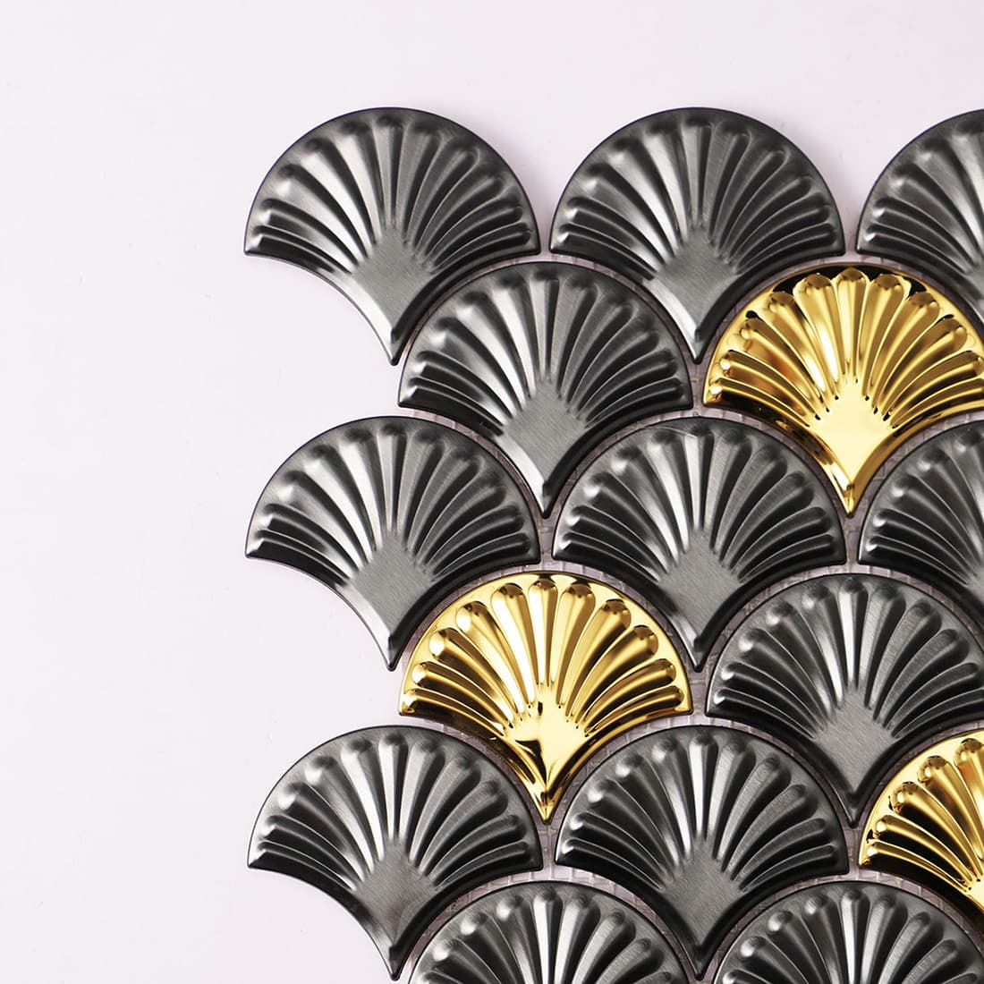 Side view of a charcoal and gold scallop mosaic tile sheet against a white background.