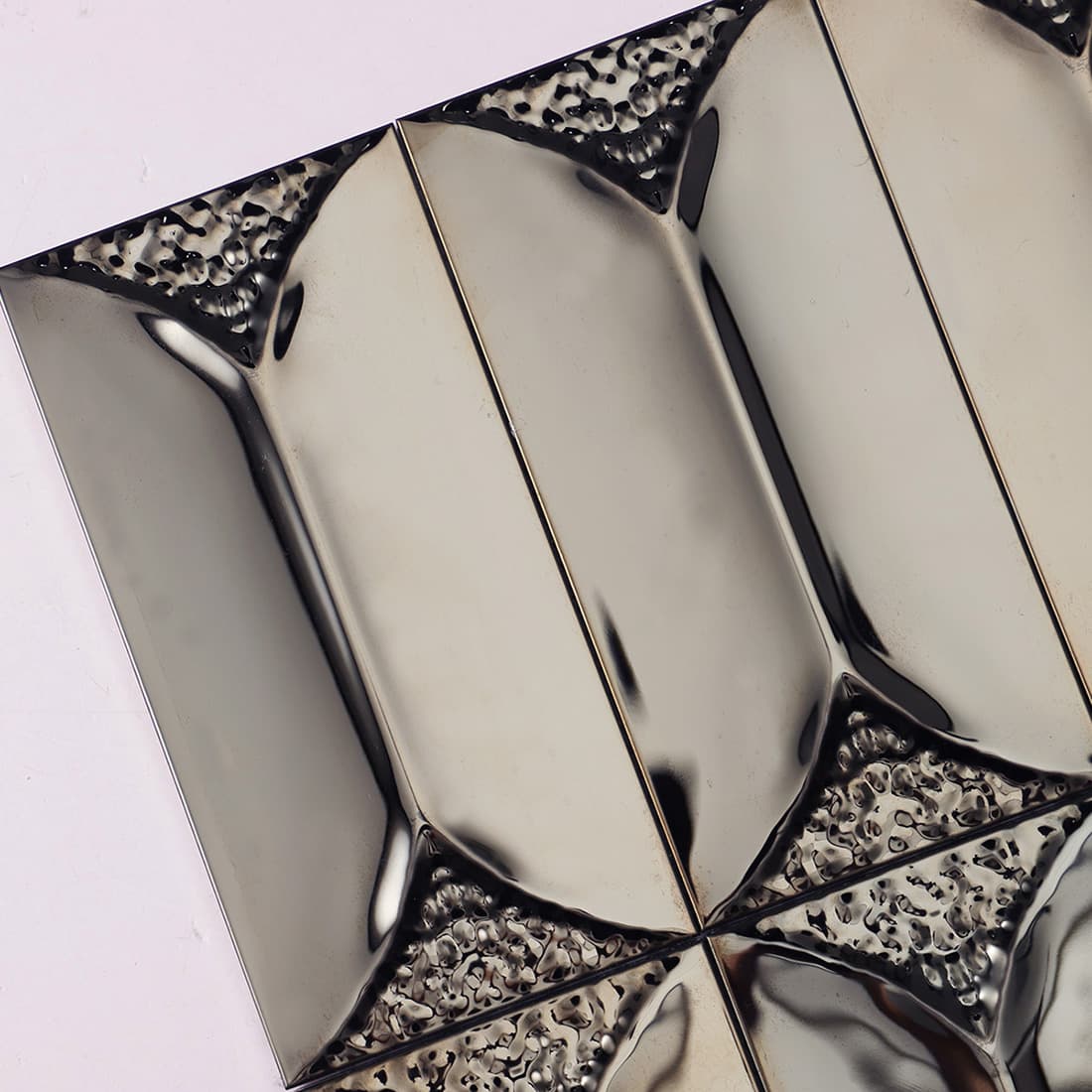 Detailed view of 3D black metal tiles with pebbled textured accents.