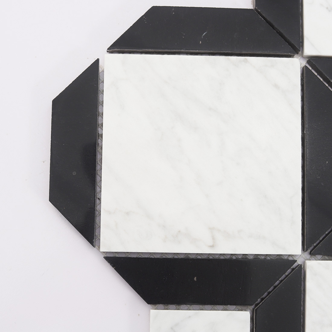 Close up of black frame white marble tile with sharp geometric corner pieces
