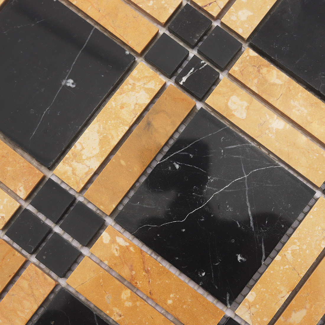 Close up of black and yellow geometric marble tile with natural veining