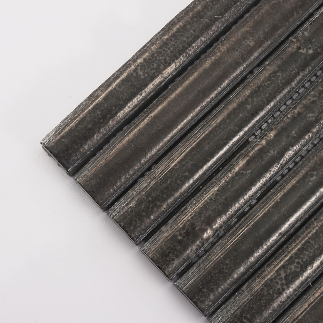 Close up of chocolate brown fluted natural stone strips with rounded edges