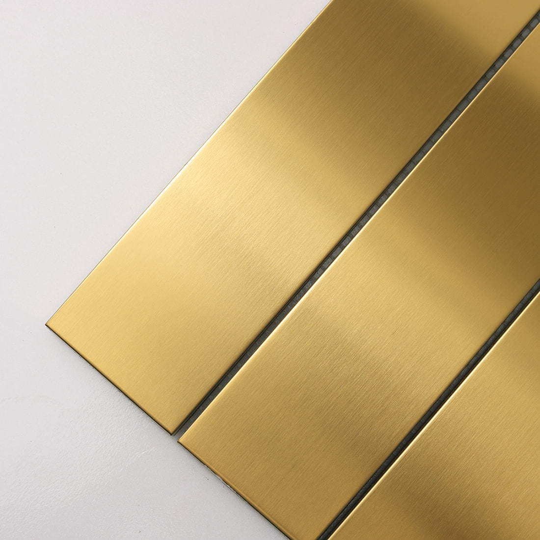 Close-up view showing the brushed texture of gold linear tiles.