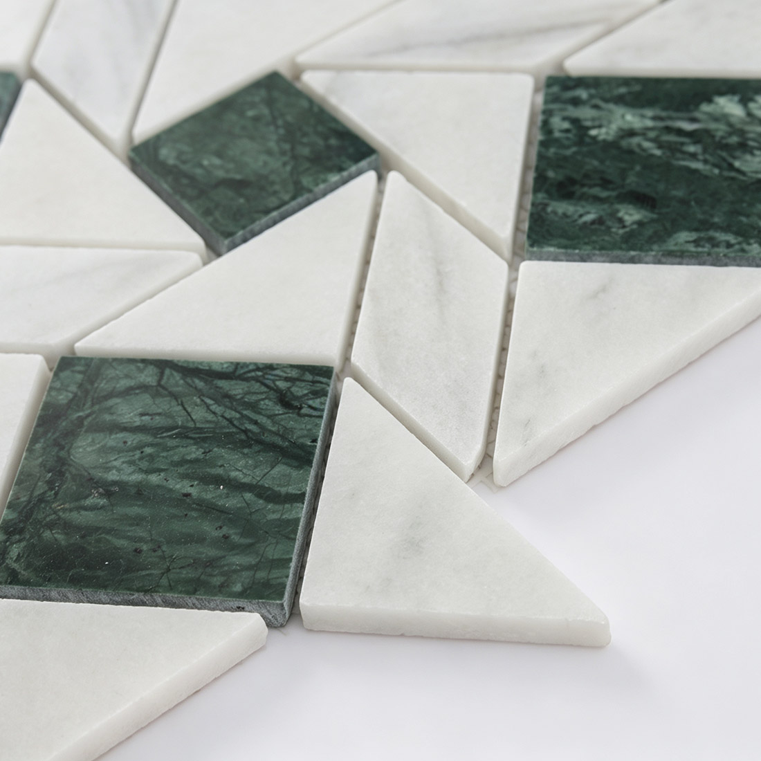 Close-up showing the side edge profile of green and white marble geometric tile.