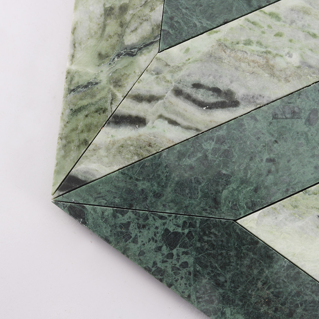 Close up of green and white triangle marble mosaic with sharp geometric lines