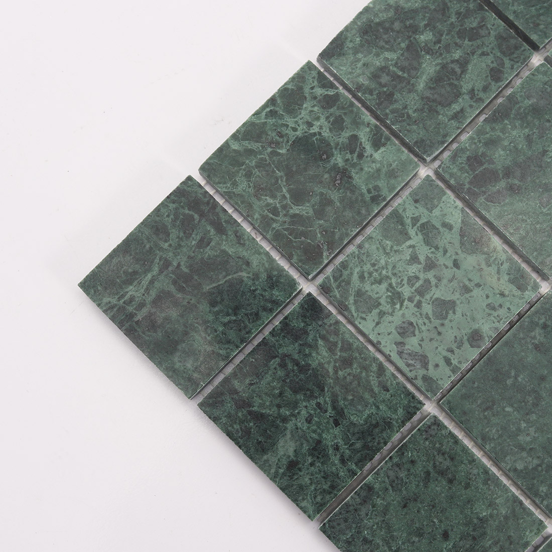 Close up of large green square marble mosaic tile with dark stone texture