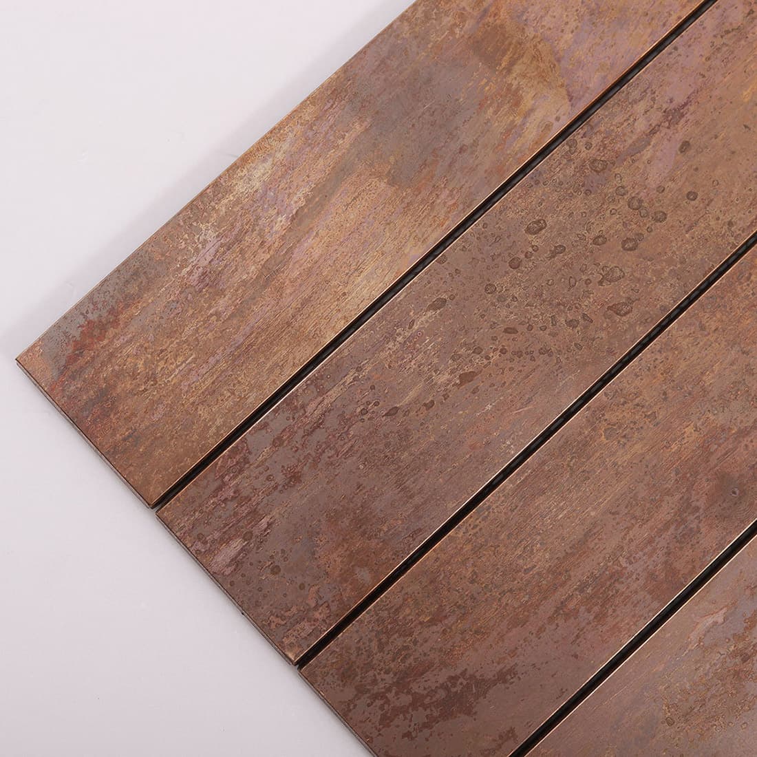 Close up of oxidized copper strip metal tile with natural patina finish