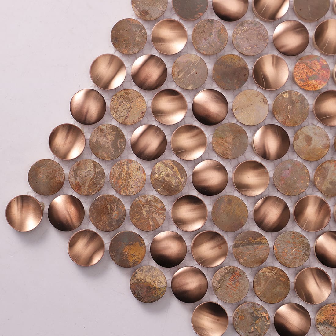 Close up of rustic copper penny round mosaic tile with aged metal texture