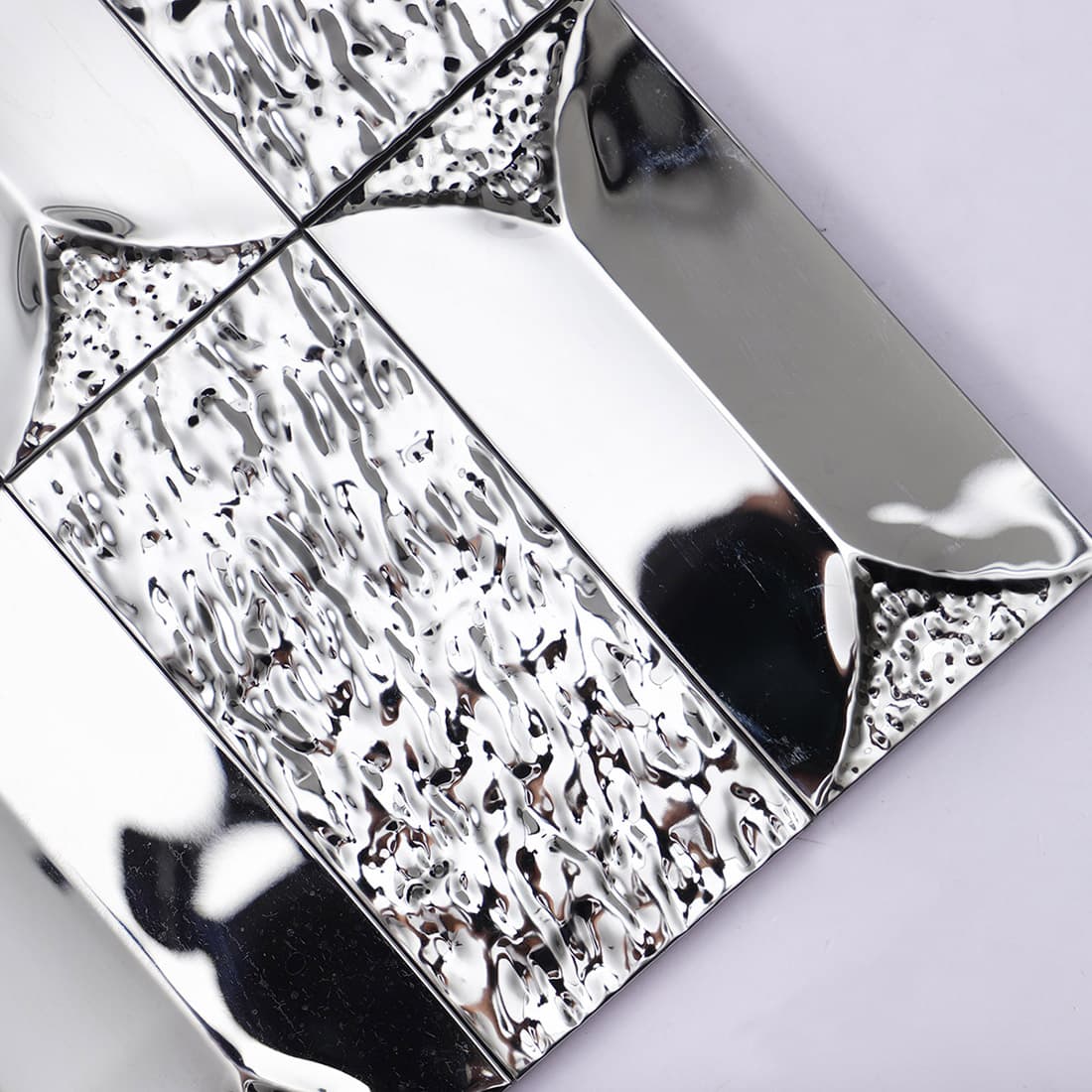 Close-up angled view of silver mirror and ripple finish beveled tiles.