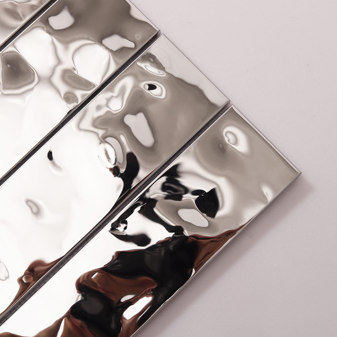 Diagonal close-up of shiny silver water ripple linear metal strips.
