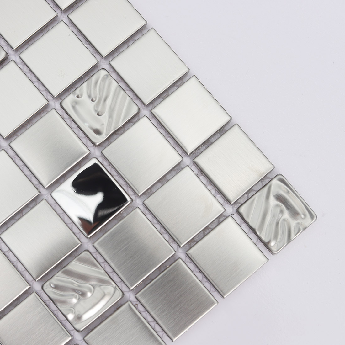 Close up of silver stainless steel square mosaic tiles with brushed and wavy pieces
