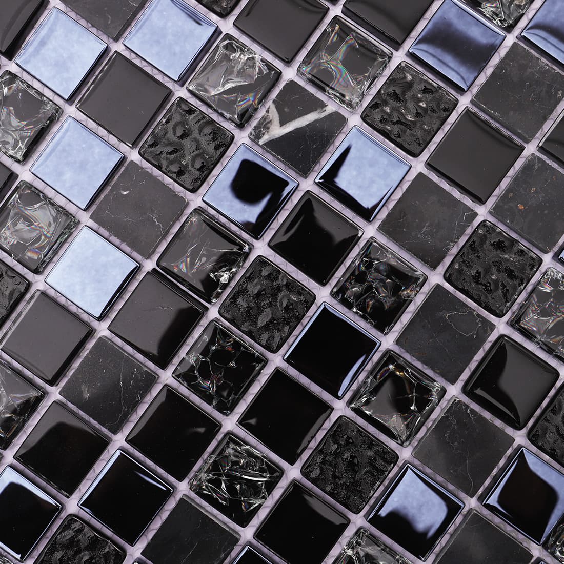 Detailed close up of the glossy and textured surfaces on black mosaic tile.