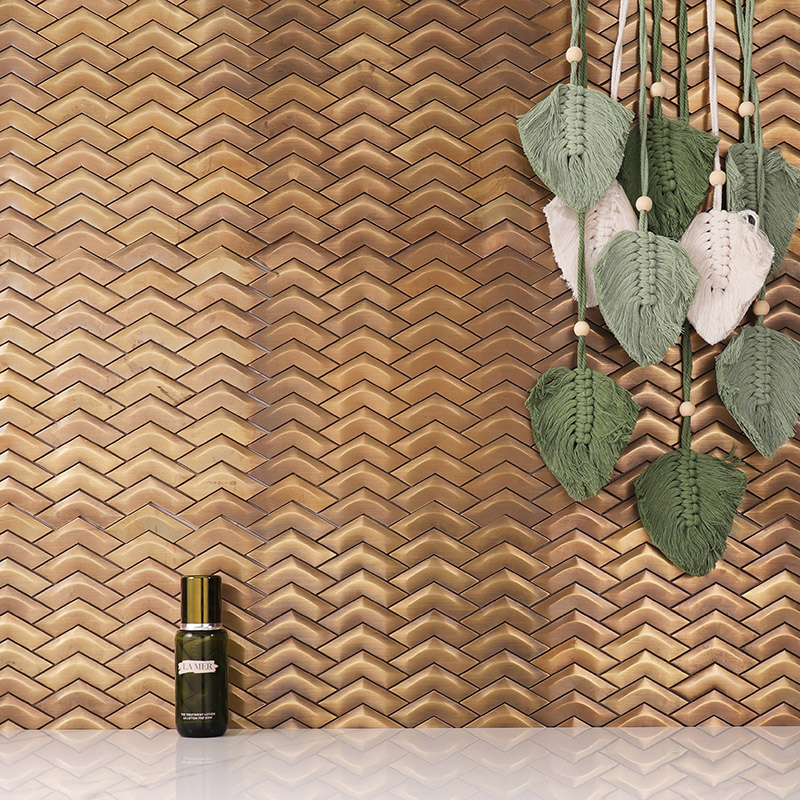 Copper Tiles in 3D chevron pattern with a vintage brass finish for luxury wall decor.