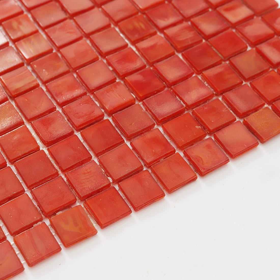 Edge close-up of coral red square glass mosaic tile sheet