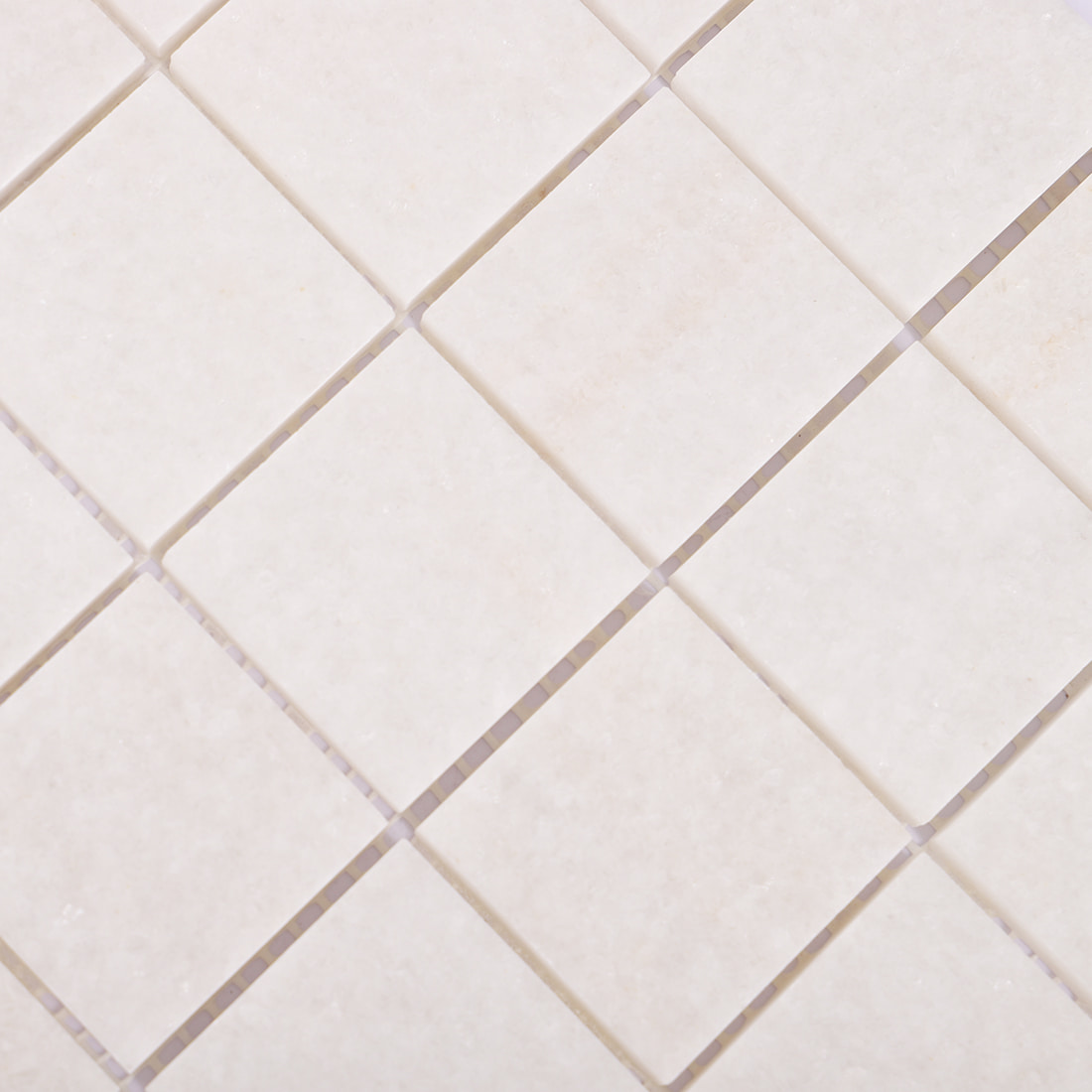 Close up of cream square marble mosaic with soft natural stone texture
