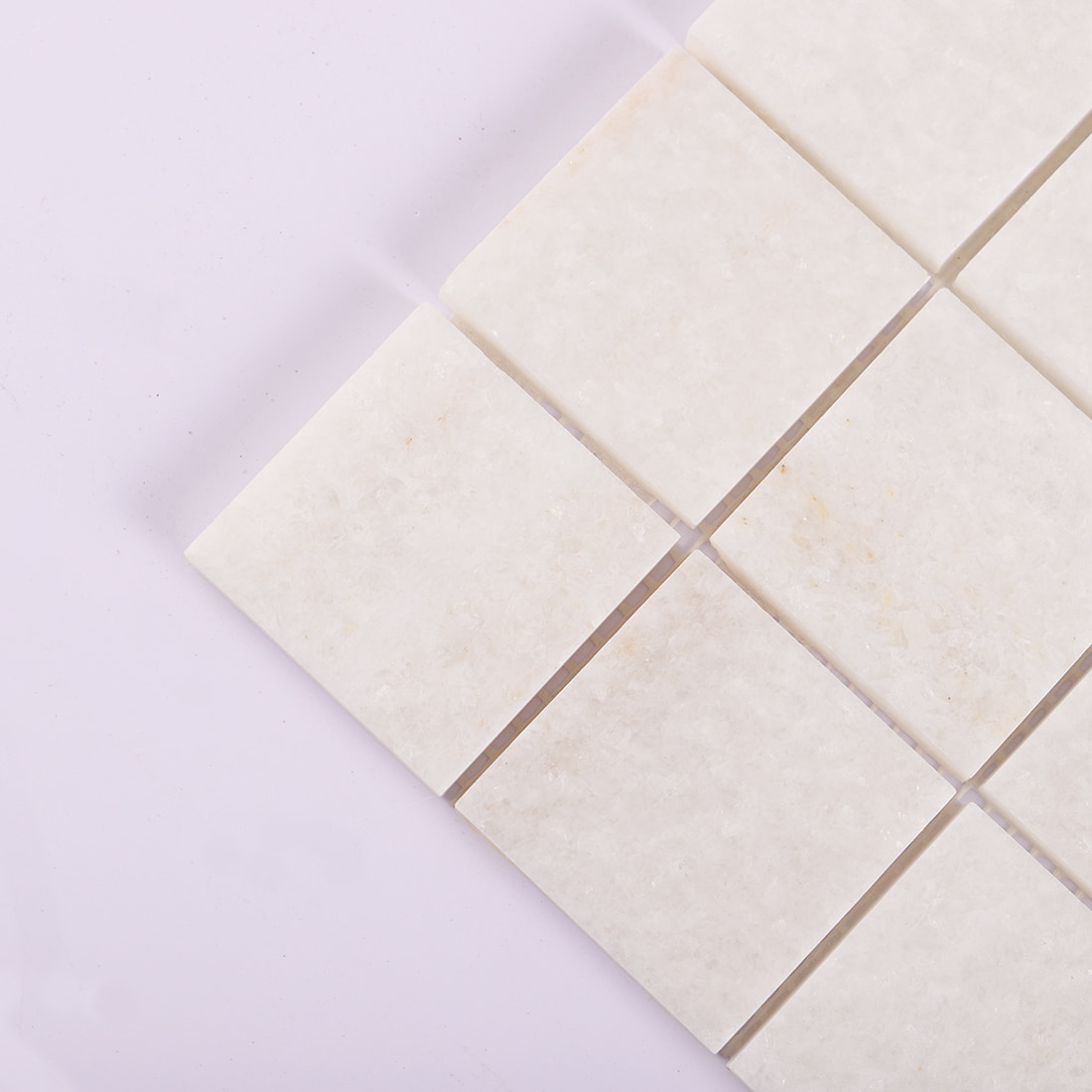 Corner detail of cream square marble mosaic tile