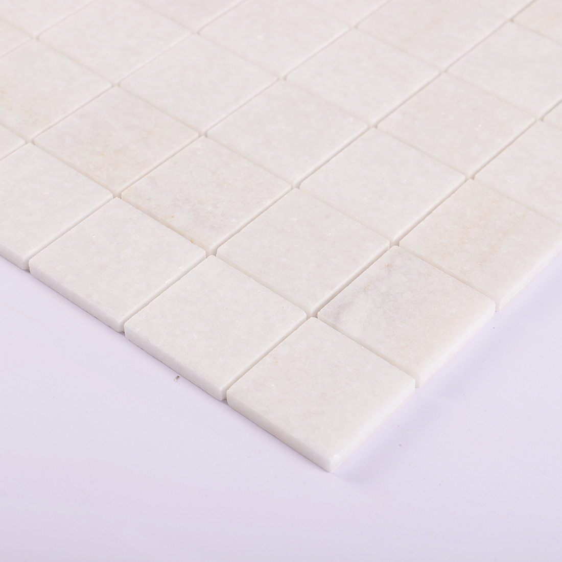 Edge detail of cream square marble mosaic tile sheet