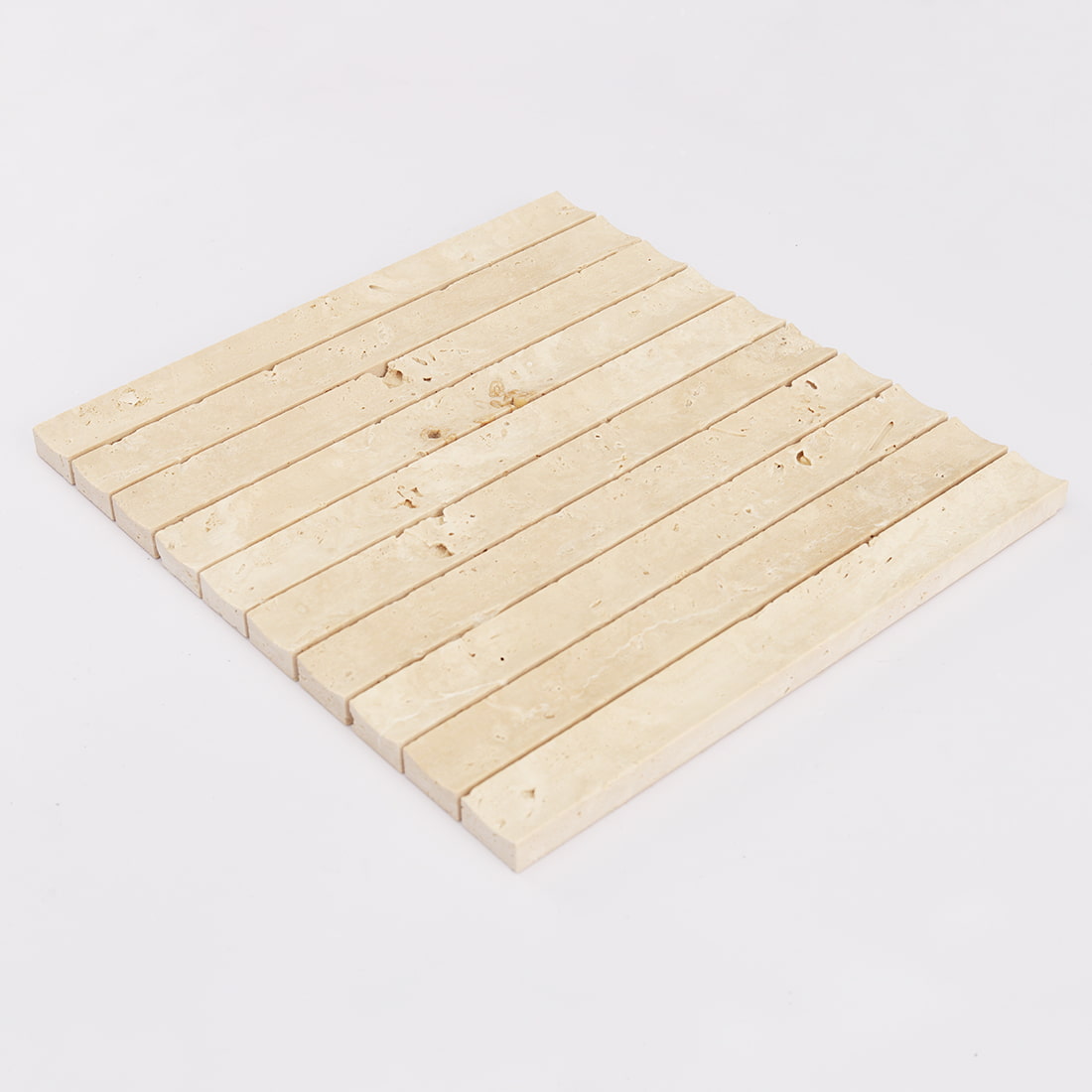 Angled view of cream travertine fluted strip mosaic tile sheet