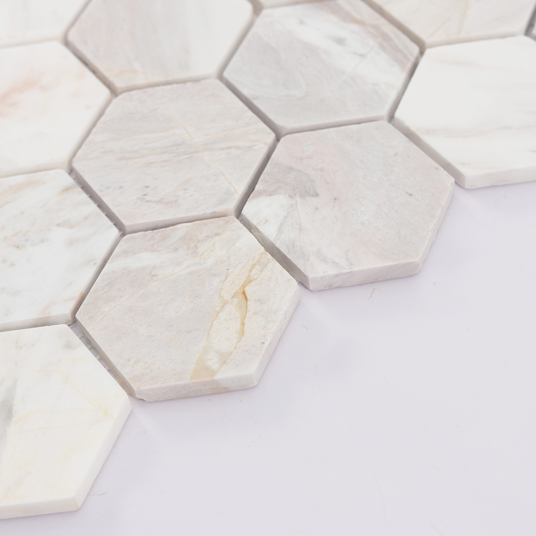 Angled view of cream white hexagon marble mosaic showing tile thickness